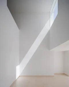 Modern, minimalist white interior space with concrete walls and floor.