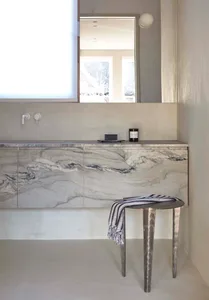 A modern bathroom featuring marble and concrete elements.