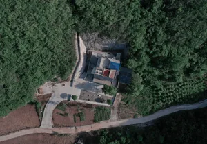 Aerial view of a modern house featuring concrete and wooden materials.