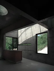 A modern kitchen with concrete walls and a dark interior design