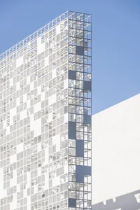 Modern glass office building against a blue sky.