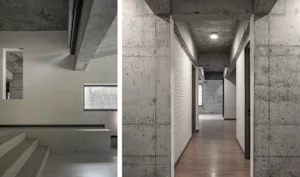 A modern interior with minimalist design featuring concrete walls in a spacious hallway.