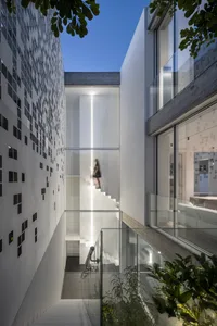 A modern minimalist house with a glass staircase.