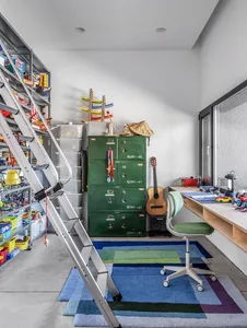 A garage with industrial-style metal cabinets, a concrete floor, and various toys and tools.