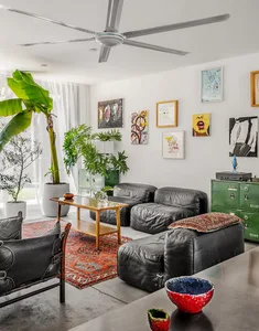 A living room with industrial design elements, featuring leather sofas, metal accents, and wooden coffee table.