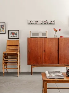 A minimalist living room featuring wooden furniture and a wooden sideboard.