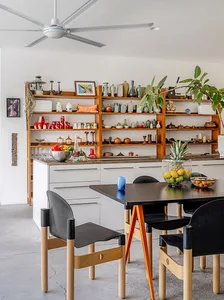 A modern kitchen featuring wooden furniture and metallic accents.