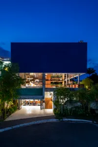 Modern residential building with glass facade at dusk.