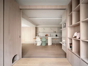 Minimalist kitchen area with wooden flooring, minimalist furniture, and built-in storage.