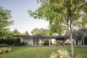 A modern, minimalist residential exterior featuring a clean, uncluttered design with concrete, glass, and metal materials.