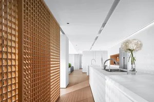 A modern minimalist kitchen featuring white marble countertops and wooden accents.