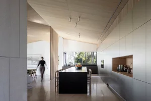 A modern residential kitchen featuring dark wood cabinets and a matte black kitchen island