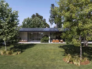 A modern residential exterior featuring a flat roof, large glass windows, and a well-manicured lawn.