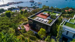 An aerial view of a modern residential design featuring glass and wood materials.