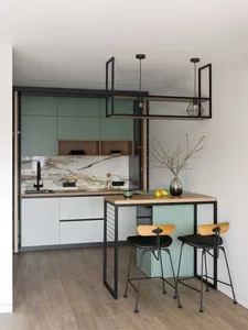 Modern apartment kitchen featuring concrete countertops, white cabinets, and minimalist design.