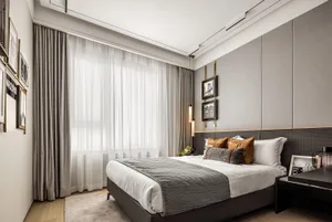 Modern bedroom featuring minimalist furniture and curtains.
