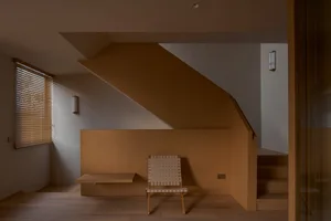 Modern minimalist home office with wooden walls and a single chair.