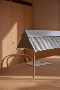 A minimalist metallic structure on a wooden table.