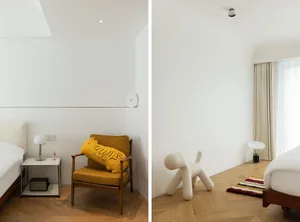 Modern minimalist bedroom with white walls, wooden floors, and minimalist furniture.