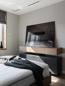 Modern bedroom featuring wooden headboard, glass TV cabinet, and metal furniture.