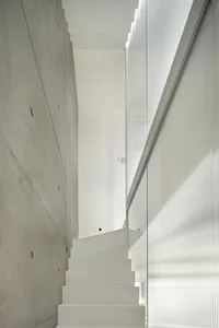 A minimalist, modern indoor staircase made of concrete.