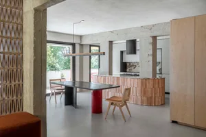 Industrial-style kitchen with concrete columns, marble countertops, and modern furnishings.