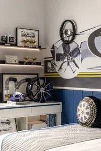 A minimalist bedroom featuring a concrete floor and decorative wall art depicting wheels and car parts.