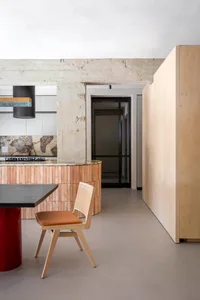A minimalist residential kitchen with concrete and wooden surfaces and a modern design.