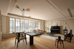 A modern living room with wooden flooring, glass windows, and leather furniture.
