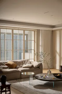 Modern residential living room with neutral tones and floor-to-ceiling windows