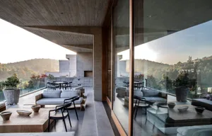 Outdoor living area with modern furniture and concrete walls.