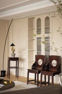 An elegant, modern living room featuring wooden furniture, glass cabinets, and soft textiles.