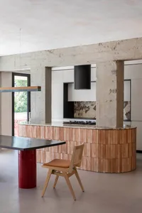 A modern minimalist kitchen featuring a wooden kitchen island and pendant lighting.