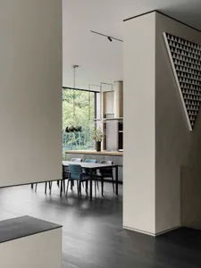 Modern minimalist kitchen with concrete flooring and dining area.
