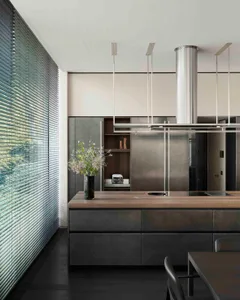 Modern residential kitchen with metal cabinets and wooden countertop.