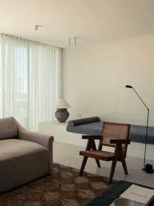 Modern minimalist living room with neutral-colored furniture and natural light.