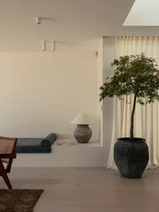 Modern residential interior with concrete flooring and corner seating area.