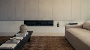 A modern minimalist living room featuring a concrete fireplace wall, wood paneled walls, and a comfortable couch.