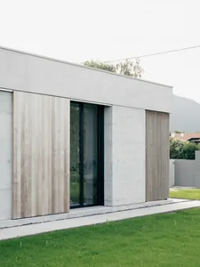 Modern house with concrete and wooden exterior in a residential area.