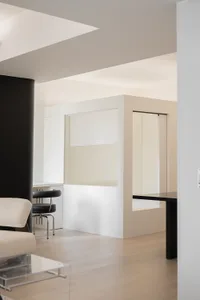 A modern, minimalist office space featuring glass walls, wooden surfaces, and metallic accents.