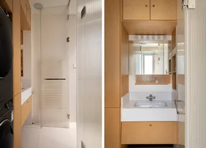 Modern bathroom with glass shower enclosure, wooden cabinets, and concrete floor