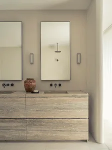 Modern bathroom with stone countertops, minimalist design, and a sink with a vase and soap bar.
