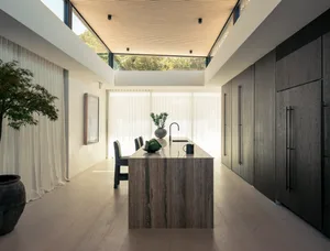 A modern, contemporary kitchen featuring elegant marble laminate countertops, sleek cabinets, and a large island.