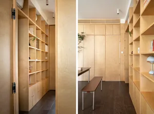 A modern minimalist interior featuring wooden furniture, shelves, and cabinetry.