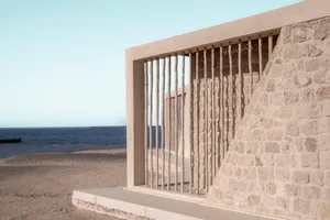 A minimalist seaside pavilion constructed from concrete and bamboo