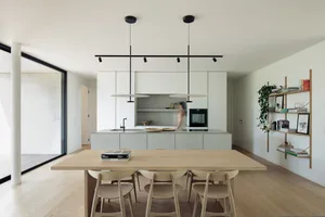 A modern, minimalist kitchen featuring concrete countertops and wooden elements.