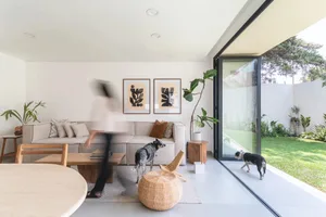 A modern living room with a neutral color palette showcasing plush seating, stylish decor, and a seamless transition to an ou