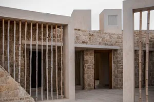 A modernist building exterior made of stone, wood, and concrete.