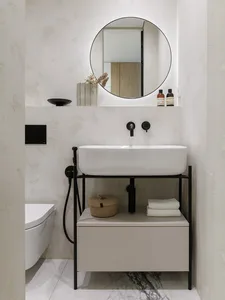 Modern minimalist bathroom featuring concrete walls, metal fixtures, and ceramic sink with storage underneath.