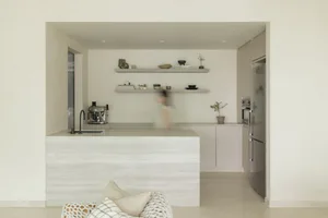 Modern, minimalist kitchen with concrete countertops and shelves.